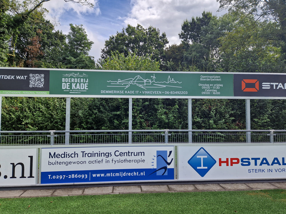 Sponsorbord Boerderij De Kade langs het sportveld
