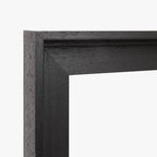 Detail van de zwarte houten baklijst met zichtbare houtnerf en hoekverbinding